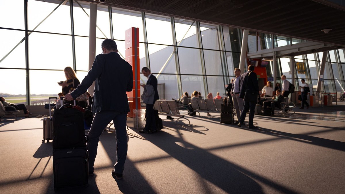Pessoa em terminal de aeroporto, representando chegada e primeiros passos após a nomeação.