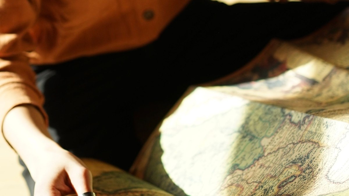 Mulher sentada lendo mapa para escolher região onde morar.