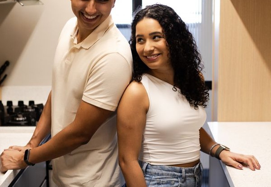 Casal brasileiro em casa, na cozinha, organizando a rotina familiar antes de escolher moradia em Brasília.